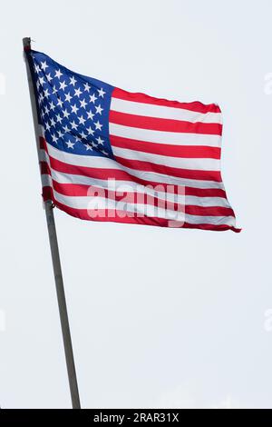Die amerikanische Flagge mit Sternen und Streifen im Wind, die geneigte Position zeigt Dynamik, Action, Bewegung. Stockfoto