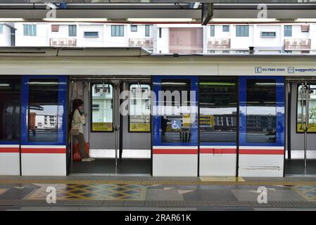 petaling jaya, Malaysia - 30. juli 2022 : Asiatische junge Frauen mit Smartphone im Pendlerzug am Bahnsteig Stockfoto