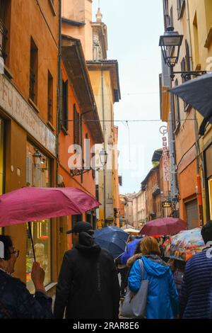 Mai 2023 Bologna, Italien: Enge Gassen der Altstadt bei Regen. Besichtigungstour mit Sonnenschirmen Stockfoto