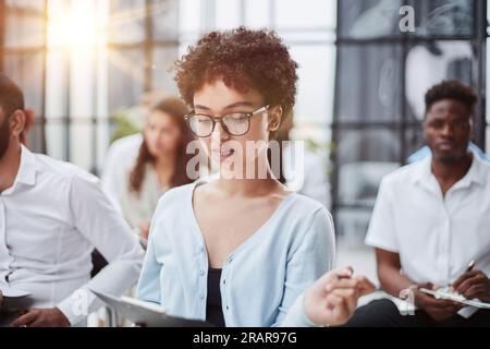 Gruppe verschiedener Mitarbeiter, die bei Vorstandssitzungen in einem modernen Büro oder Konferenzraum lernen Stockfoto
