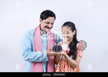 Ein indischer Landvater, der seiner Teenager-Tochter die Bedeutung von Zeit und diszipliniertem Leben erklärt. Stockfoto