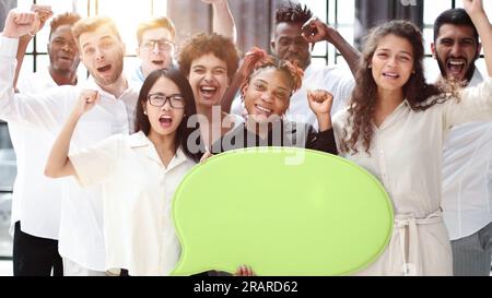 Junge Gruppe von Menschen, die Sprachblasen in modernen Büros halten Stockfoto