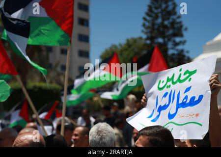 Während einer Demonstration in Gaza-Stadt, bei der gegen eine israelische Militäroperation im besetzten Westjordanland protestiert wurde, heben Palästinenser nationale Flaggen und Plakate. Israel hat seine Einsätze im nördlichen Westjordanland, in dem die Stadt Dschenin und das angrenzende Flüchtlingslager untergebracht sind, verstärkt. Gaza-Stadt, Palästina. Stockfoto