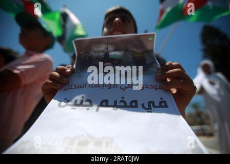 Während einer Demonstration in Gaza-Stadt, bei der gegen eine israelische Militäroperation im besetzten Westjordanland protestiert wurde, heben Palästinenser nationale Flaggen und Plakate. Israel hat seine Einsätze im nördlichen Westjordanland, in dem die Stadt Dschenin und das angrenzende Flüchtlingslager untergebracht sind, verstärkt. Gaza-Stadt, Palästina. Stockfoto