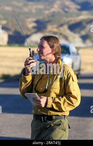 Joy Logan, Motorenführer des Dinosaur National Monument, spricht per Funk mit dem Piloten eines Flugzeugs, das am 11. August 2022 dem Moonshine Fire in der Nähe von Jensen, Utah, zugeteilt wurde. Das Feuer, das vom Blitz ausgelöst wurde, brannte auf dem Yampa-Plateau auf der Utah-Seite des Denkmals. Stockfoto