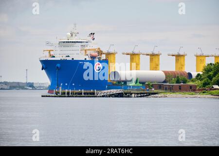 Halifax, Nova Scotia, Kanada. Juli 2023. Die GPO Grace, ein Heavylift-Schiff, beladen mit Windkraftanlagen-Monopilen, das für das erste Offshore-Windenergieprojekt der USA vor der Küste von Massachusetts bestimmt ist, gelangt in den Hafen von Halifax, wo das Projekt einen Teil seines Bereitstellungsbereichs eingerichtet hat. Stockfoto