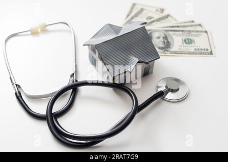 Hausinspektionskonzept. Miniatur-Heim- und Stethoskop sowie Bürobedarf auf weißem Hintergrund Stockfoto