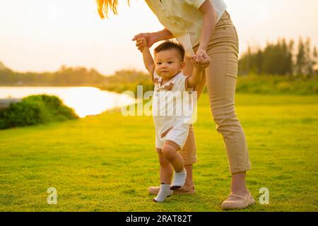 Glückliche Familie, Mutter und Sohn, die zusammen im Green Meadow Park spielen Stockfoto