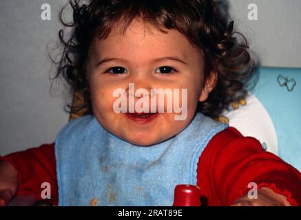 Porträt eines 14 Monate alten Kleinkindes mit Lätzchen und lächelndem England Stockfoto