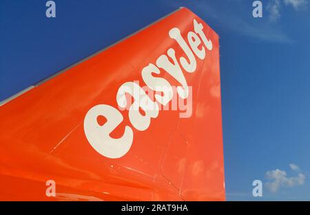 London, Vereinigtes Königreich - November 21 2018: Flugzeugschwanz mit dem Logo eines easyJet-Fluges nach Athen, Griechenland, auf blauem Himmel. Stockfoto