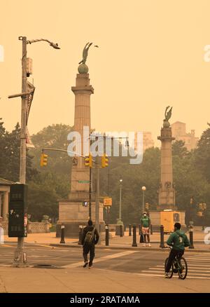 Brooklyn, NY - Juni 7 2023: Die Besucher passieren die Grand Army Plaza bei Dunst und Rauch, die durch Waldbrände in Kanada verursacht werden. Viele Leute tragen "m" Stockfoto