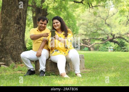 Glückliches fasto-Indianer-Paar, das Selfie in üppiger grüner Atmosphäre macht. Ruhige und ruhige Umgebung. Stockfoto