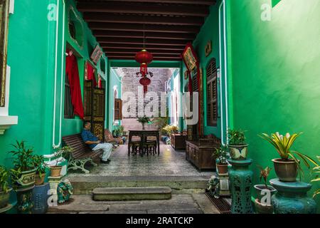 Georgetown, Penang -- 1. April 2023. Ein Mann sitzt auf einer Bank bei einer Führung durch ein Herrenhaus in Georgetown Penang Stockfoto