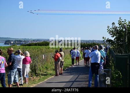 Während der englischen Riviera Airshow 2023 beobachten Menschen die roten Pfeile über Torbay. Stockfoto