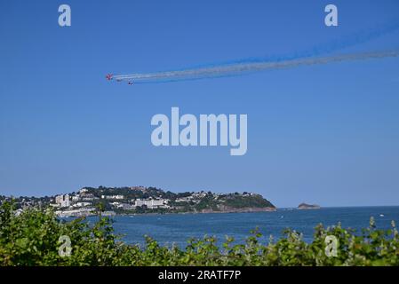 Die roten Pfeile über Torbay während der englischen Riviera Airshow 2023, mit Torquay im Hintergrund. Stockfoto