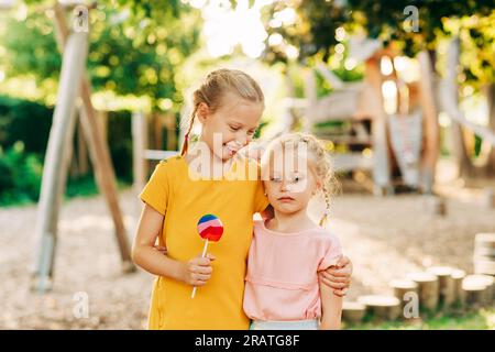 Große Schwester, die ein kleines trauriges Mädchen aufmuntert, Familienliebe und Unterstützung, Freundschaft Stockfoto