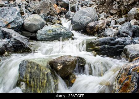 Gletscherwasser über die Felsen entlang der Seidenstraße Stockfoto