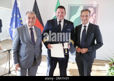 Düsseldorf, Deutschland. 05. Juli 2023. Patrick Reichelt (m), Polizeichef aus Swisttal, steht neben Herbert Reul (CDU, l), Innenminister von Nordrhein-Westfalen, und Falk Schnabel, Polizeichef von Köln, bei der Preisverleihung für die Rettungsmedaille des Landes Nordrhein-Westfalen. 18 Helfer riskierten ihr eigenes Leben, um andere Menschen während der Flutkatastrophe am 14. Und 15. Juli 2021 vor lebensbedrohlichen Notfällen zu retten. Kredit: David Young/dpa/Alamy Live News Stockfoto