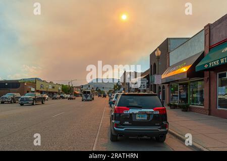 Wildfeuer im Yellowstone-Nationalpark bei Sonnenuntergang in der Innenstadt von Cody City, Wyoming, USA. Stockfoto