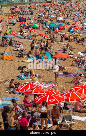 Ein sehr überfüllter Strand an einem heißen Sommertag in Brighton, East Sussex Stockfoto