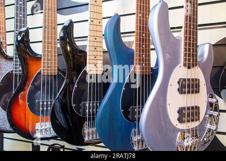 Reihen von Bassgitarren in einem Gitarrenladen Stockfoto