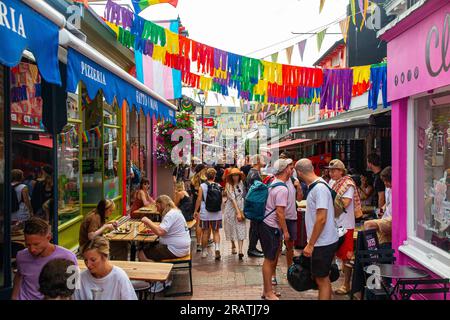 Shopping in einer der engen, unkonventionellen Straßen in Brighton. West Sussex - an einem heißen Sommertag überfüllt Stockfoto