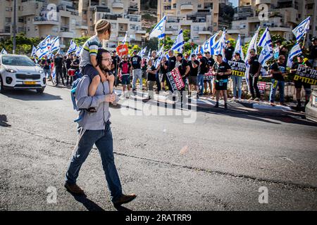 Jerusalem, Israel. 05. Juli 2023. Ein jüdischer religiöser Mann nimmt seinen Sohn auf die Schultern, während er an einem Anti-Reform-Protest vorbeigeht. Über 200 Demonstranten gegen die Justizreform der Regierung, die vor Har Hamor Jeschiwa unter der Führung von Rabbi Zvi Tau demonstriert wurden, sagten die Demonstranten, dass Jeschiwa den messianischen Strom symbolisiert, der den Staatsstreich des Regimes führt. Kredit: SOPA Images Limited/Alamy Live News Stockfoto