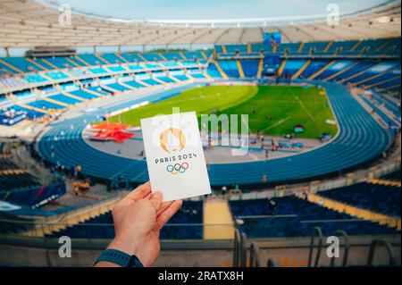 PARIS, FRANKREICH, 7. JULI 2023: Ikone der olympischen Sommerspiele Paris 2024 von Athleten. Modernes Olympiastadion im Hintergrund. Tapete für Summer Olymp Stockfoto