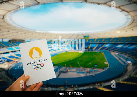 PARIS, FRANKREICH, 7. JULI 2023: Ikone der olympischen Sommerspiele Paris 2024 von Athleten. Modernes Olympiastadion im Hintergrund. Tapete für Summer Olymp Stockfoto