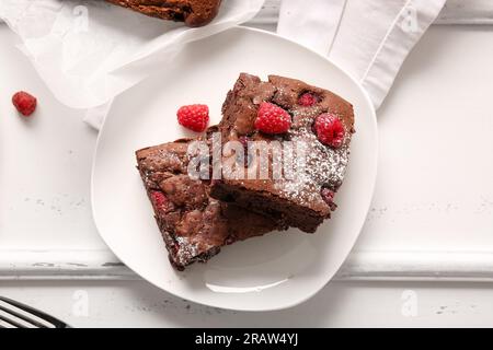 Teller mit Himbeer-Schokoladen-Brownie auf weißem Hintergrund Stockfoto