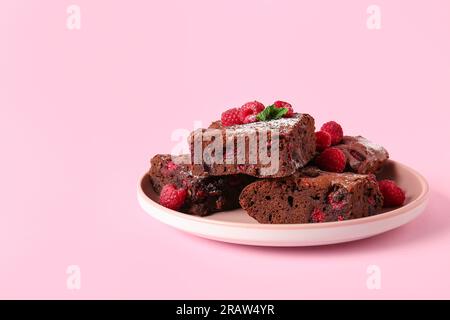 Teller mit Himbeer-Schokoladen-Brownie auf pinkfarbenem Hintergrund Stockfoto