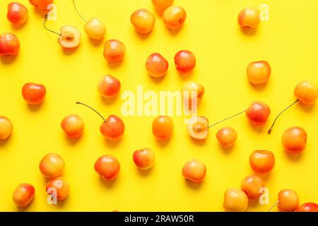 Viele süße gelbe Kirschen auf gelbem Hintergrund Stockfoto