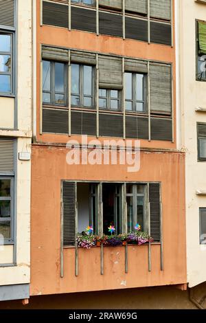 LGBT-Schilder an einem Fenster des Wohngebäudes. Regenbogenflagge LGBTQ Community Support-Symbol auf einem Balkon in Barcelona, Spanien, Europa Stockfoto