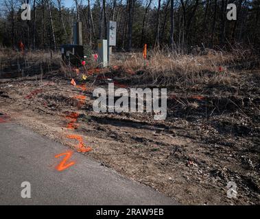 Warnflaggen und orangefarbene Markierung unterirdischer Versorgungsleitungen auf einer Baustelle, die vor Grabungen in der Erde verwendet werden. Stockfoto