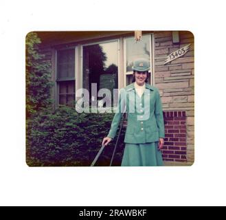 Panamerikanische Flugbegleiterin posiert in Uniform vor einem Wohnhaus, 1970er, USA Stockfoto