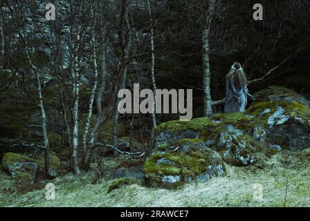 Heidnische Frau, die der Göttin im Wald ein Opfer bringt. Stockfoto