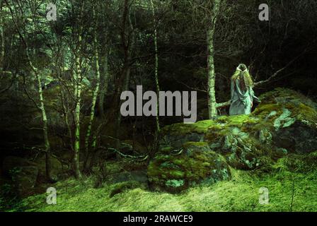 Heidnische Frau, die der Göttin im Wald ein Opfer bringt. Stockfoto