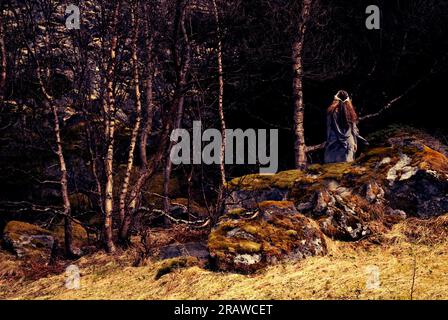 Heidnische Frau, die der Göttin im Wald ein Opfer bringt. Stockfoto