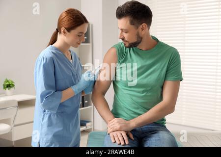 Arzt, der dem Patienten in der Klinik Hepatitis-Impfstoff gibt Stockfoto