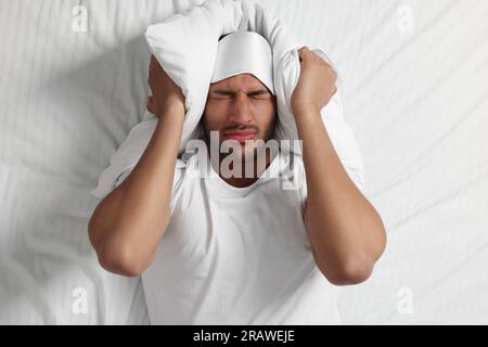 Mann mit Schlafstörungen im Bett, Draufsicht Stockfoto