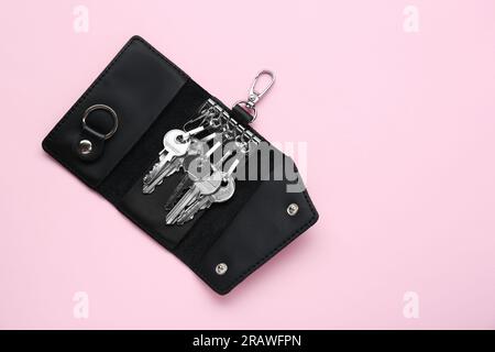 Lederringhalter mit Schlüsseln auf pinkfarbenem Hintergrund, Draufsicht. Platz für Text Stockfoto