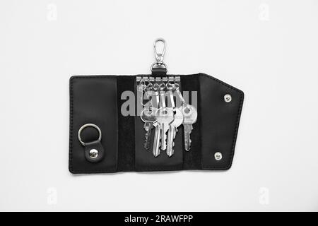 Offener Lederhalter mit Tasten auf hellgrauem Hintergrund, Draufsicht Stockfoto