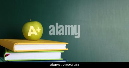 Apfel mit geschnitztem Buchstaben A und Plus als Schulklasse in Büchern nahe der grünen Tafel. Bannerdesign mit Platz für Text Stockfoto