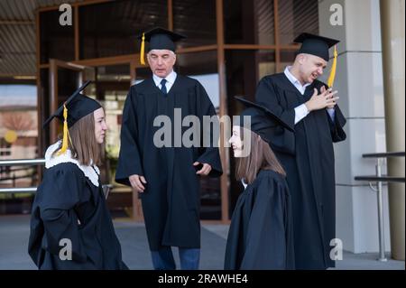 Klassenkameraden in Abschlusskleidern. Barrierefreie Bildung für alle Altersgruppen. Stockfoto