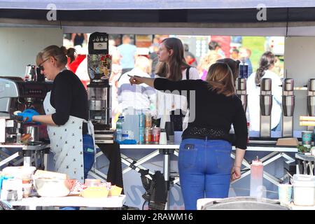 Ein von zwei Frauen geführter Catering-Stand, an dem auf der Geschäftsseite des Theaters verschiedene warme und kalte Getränke beim Great Missenden Food Festival serviert werden. Stockfoto