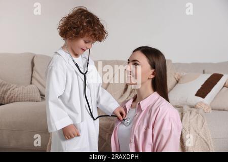 Ein kleiner Junge, der mit seiner Mutter zu Hause Arzt spielt Stockfoto