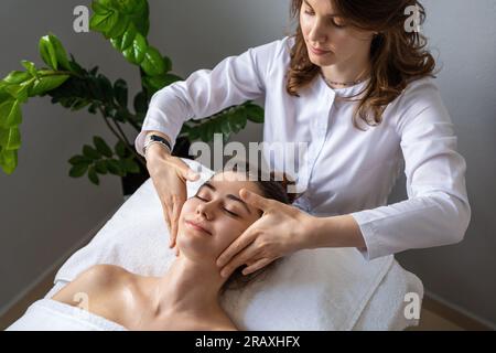 Von oben auf dem Bett liegendes junges Weibchen mit geschlossenen Augen und geniessen Massage Stockfoto