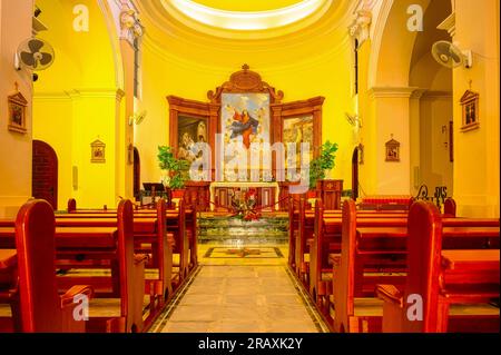 Guadalest, Alicante, Spanien - 14. Januar 2023: Kircheninnere mit Bänken, die zum Altar führen. Die Bänke sind aus Holz. Stockfoto