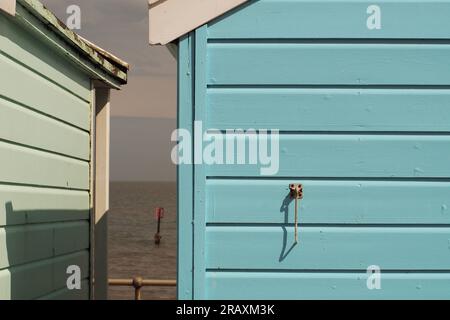 Zwischen zwei Strandhütten in Southwold, Suffolk. Großbritannien bis zum Horizont mit einem Haken an der Rückseite eines Stockfoto