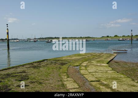 Hellbahn am Bosham Quay in Chichester Harbour, West Sussex, England. Ebbe mit verankerten Booten. Stockfoto